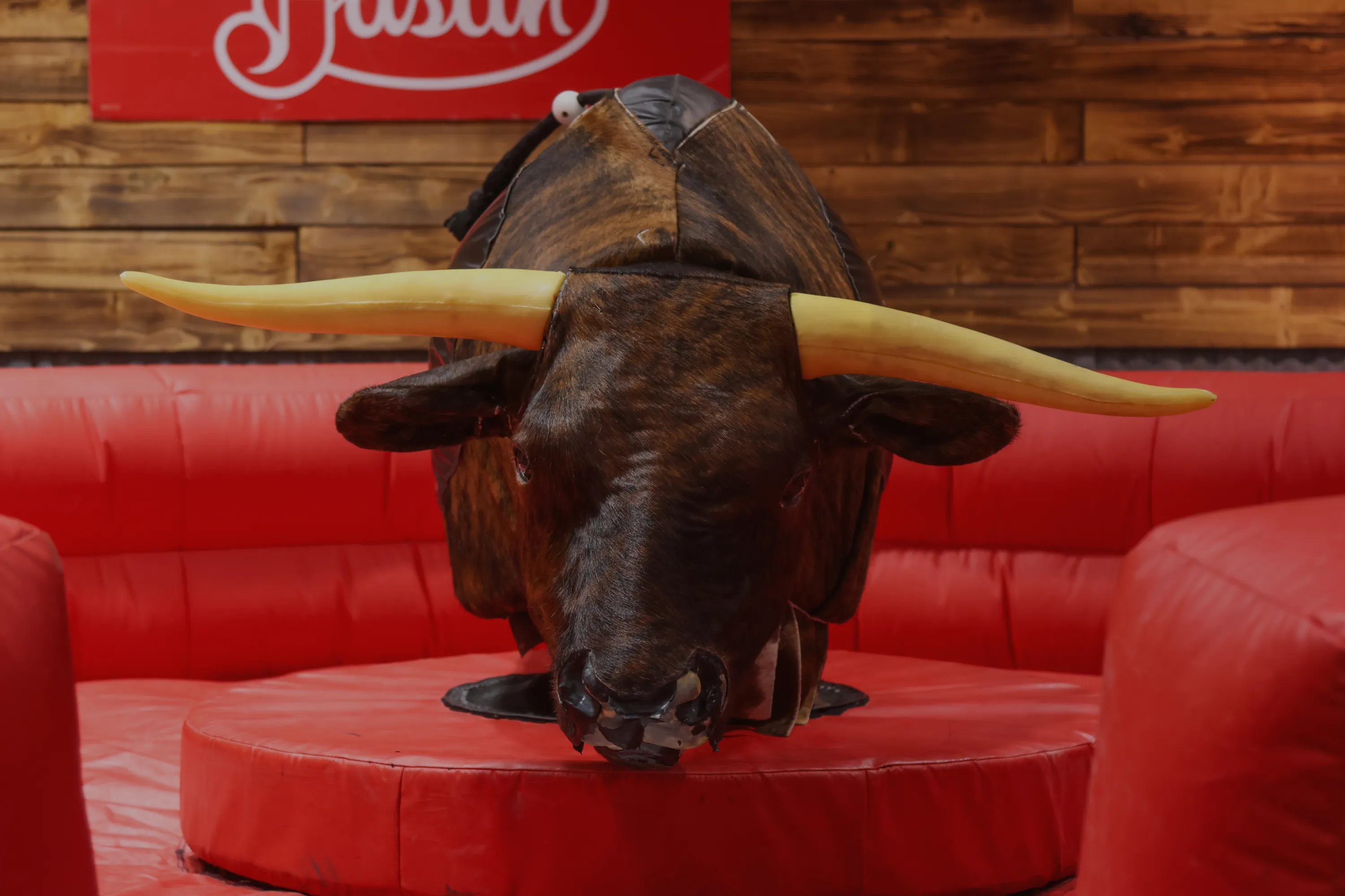 Mechanical bull on red inflatable mat ready for riders at a Utah event